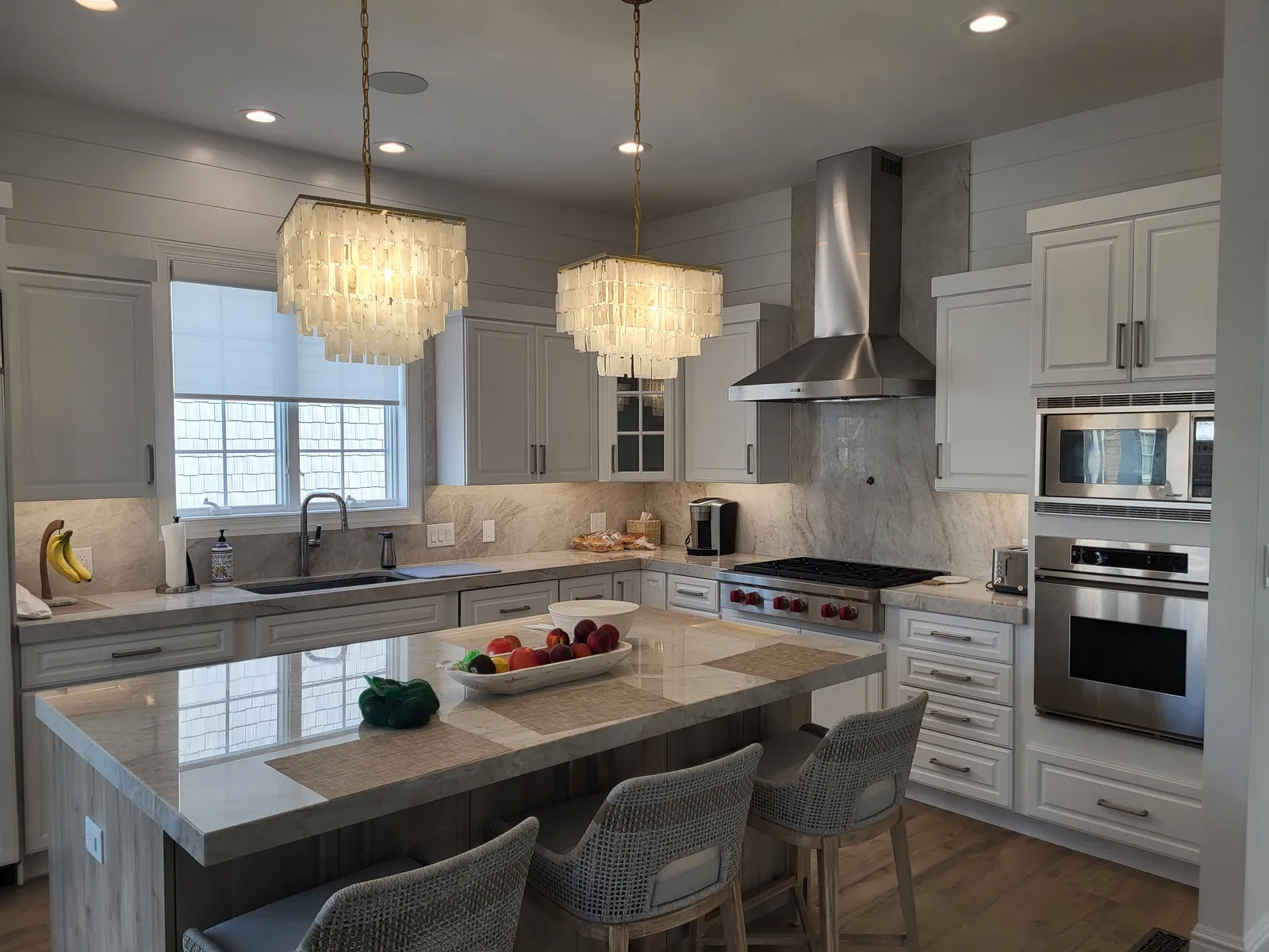 White kitchen with tiered chandeliers over the island