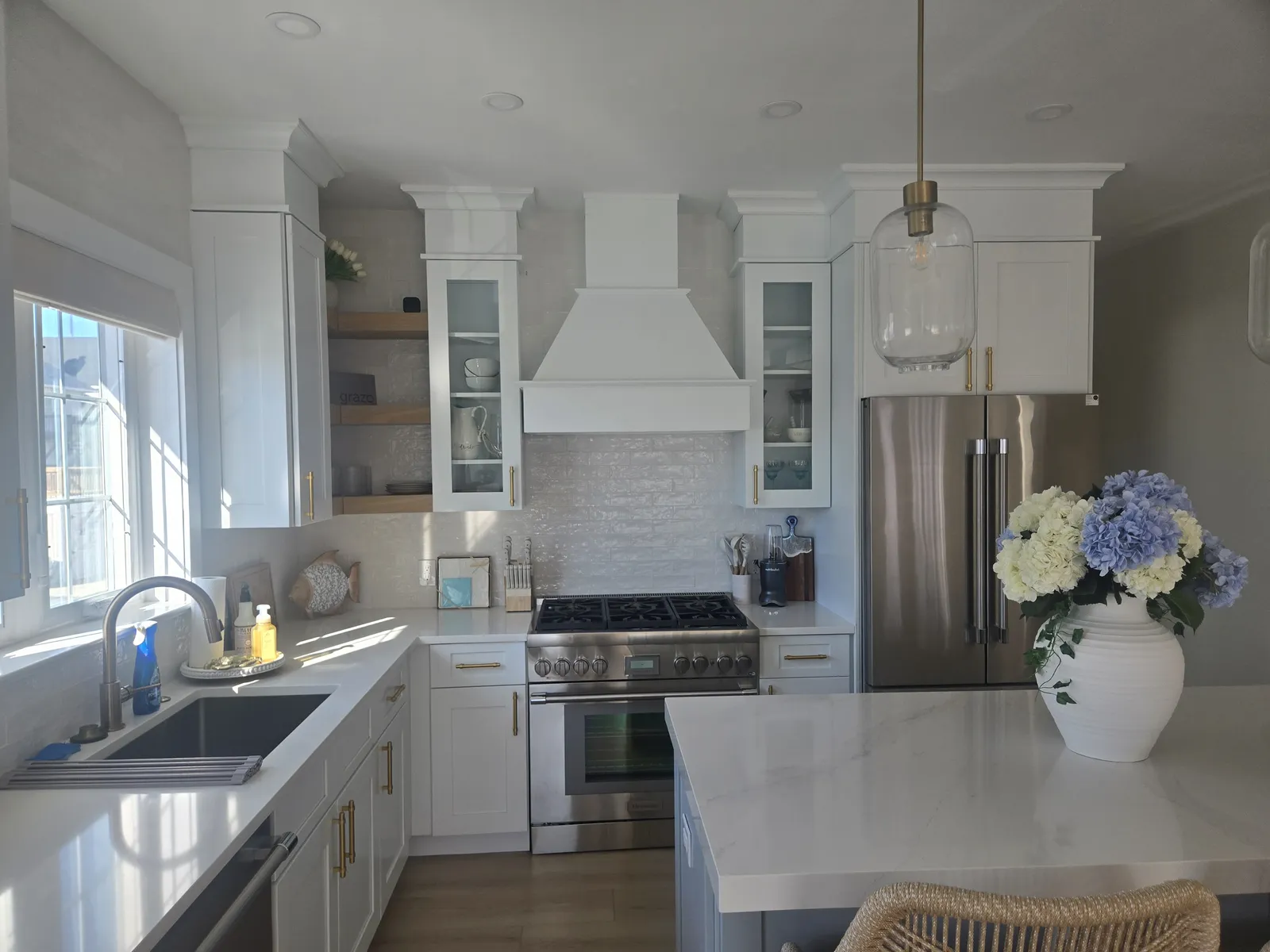 Bright white kitchen with a farmhouse sink and quartz island
