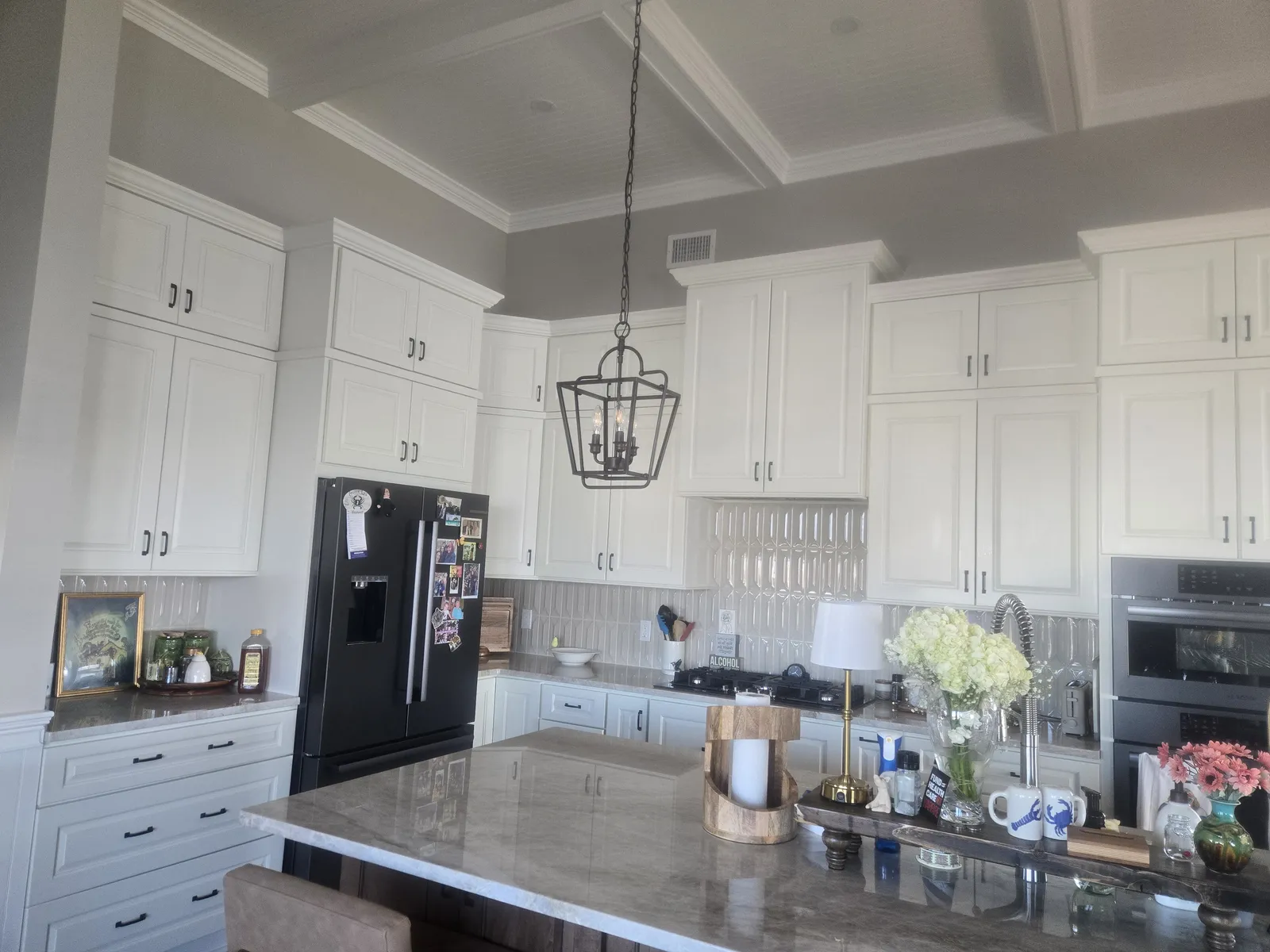White shaker kitchen with a stained wood island and lantern pendants