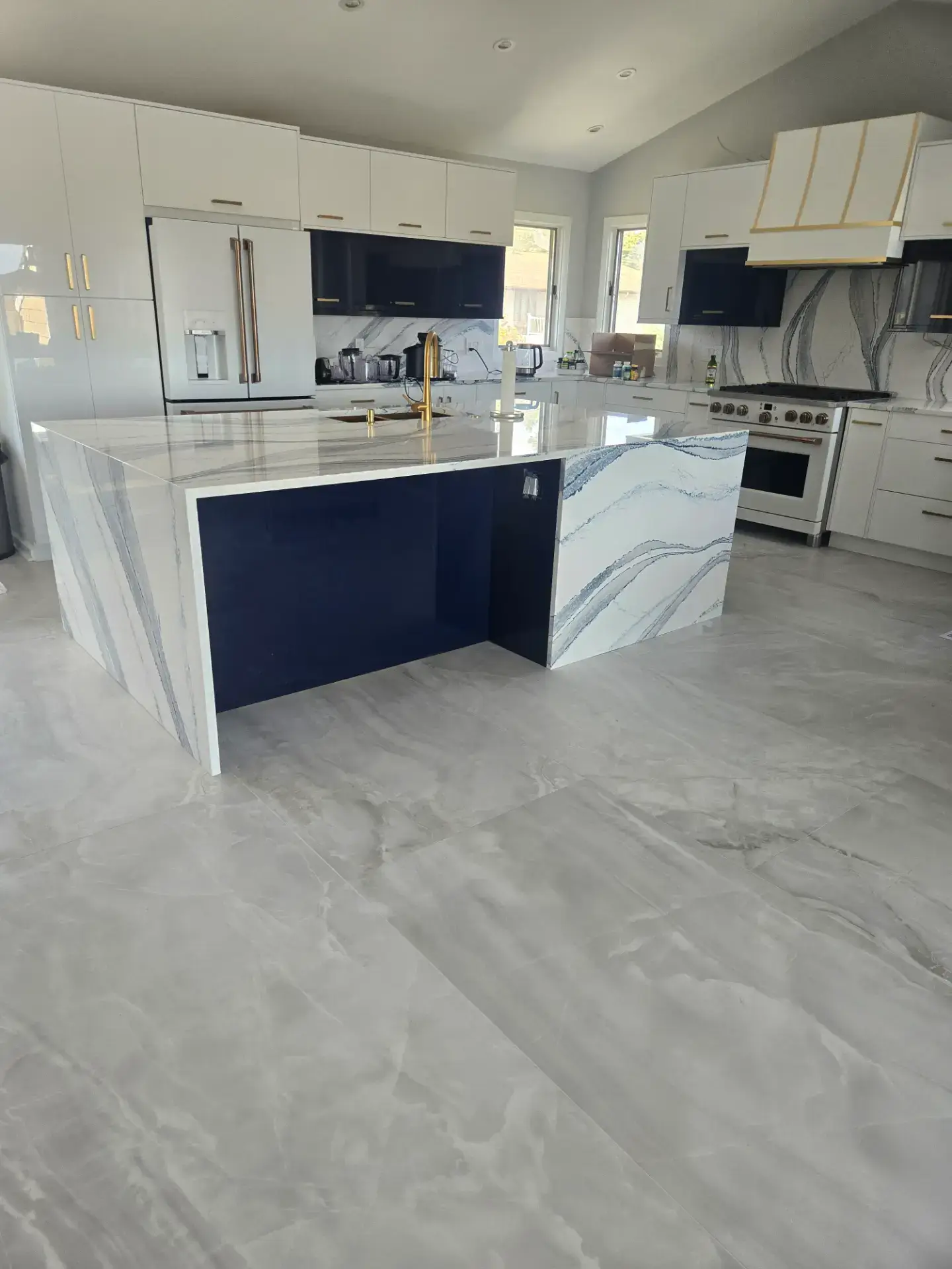 Navy island with marble countertops and tiled flooring