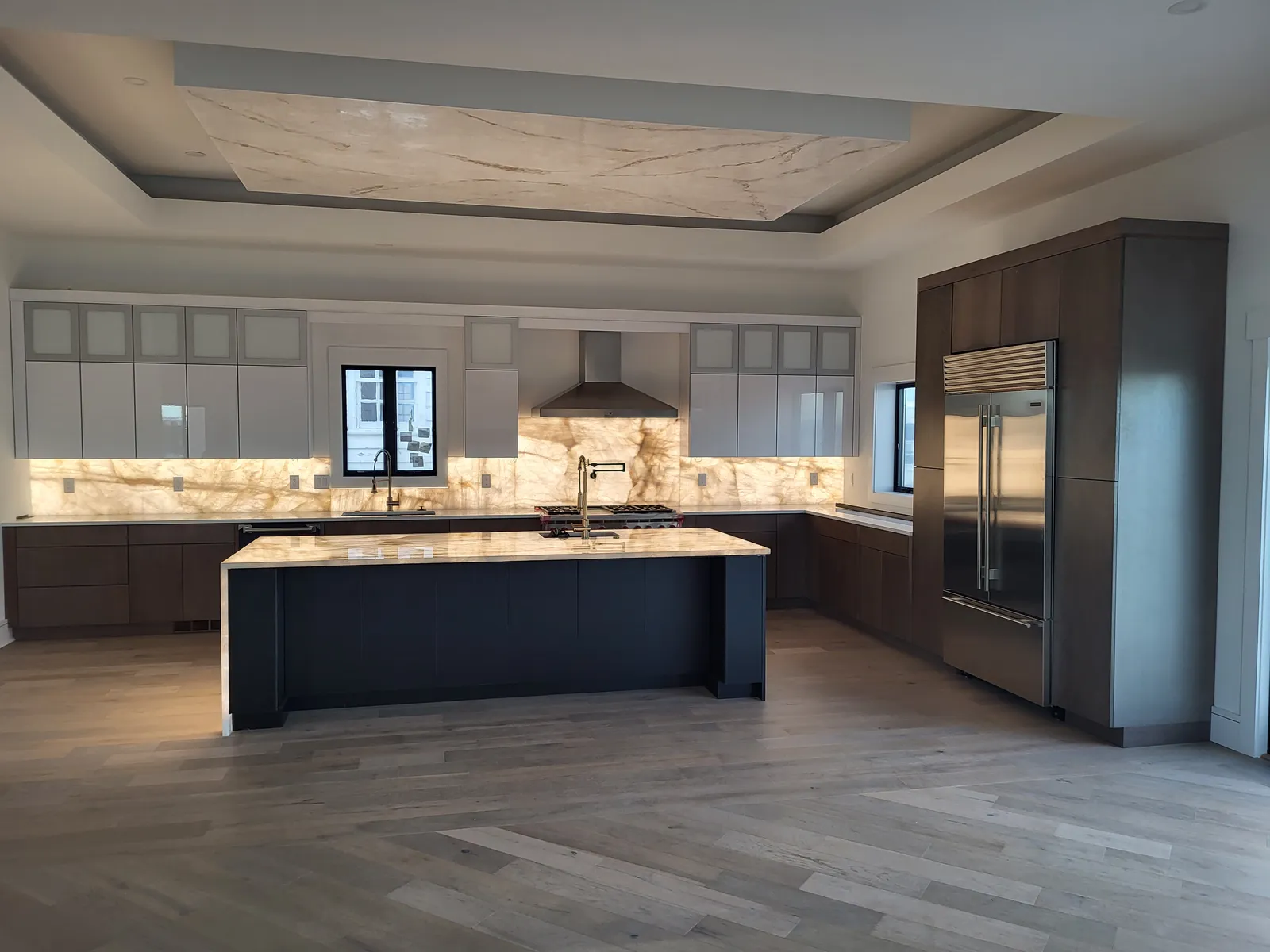 Modern walnut kitchen under a lit tray ceiling