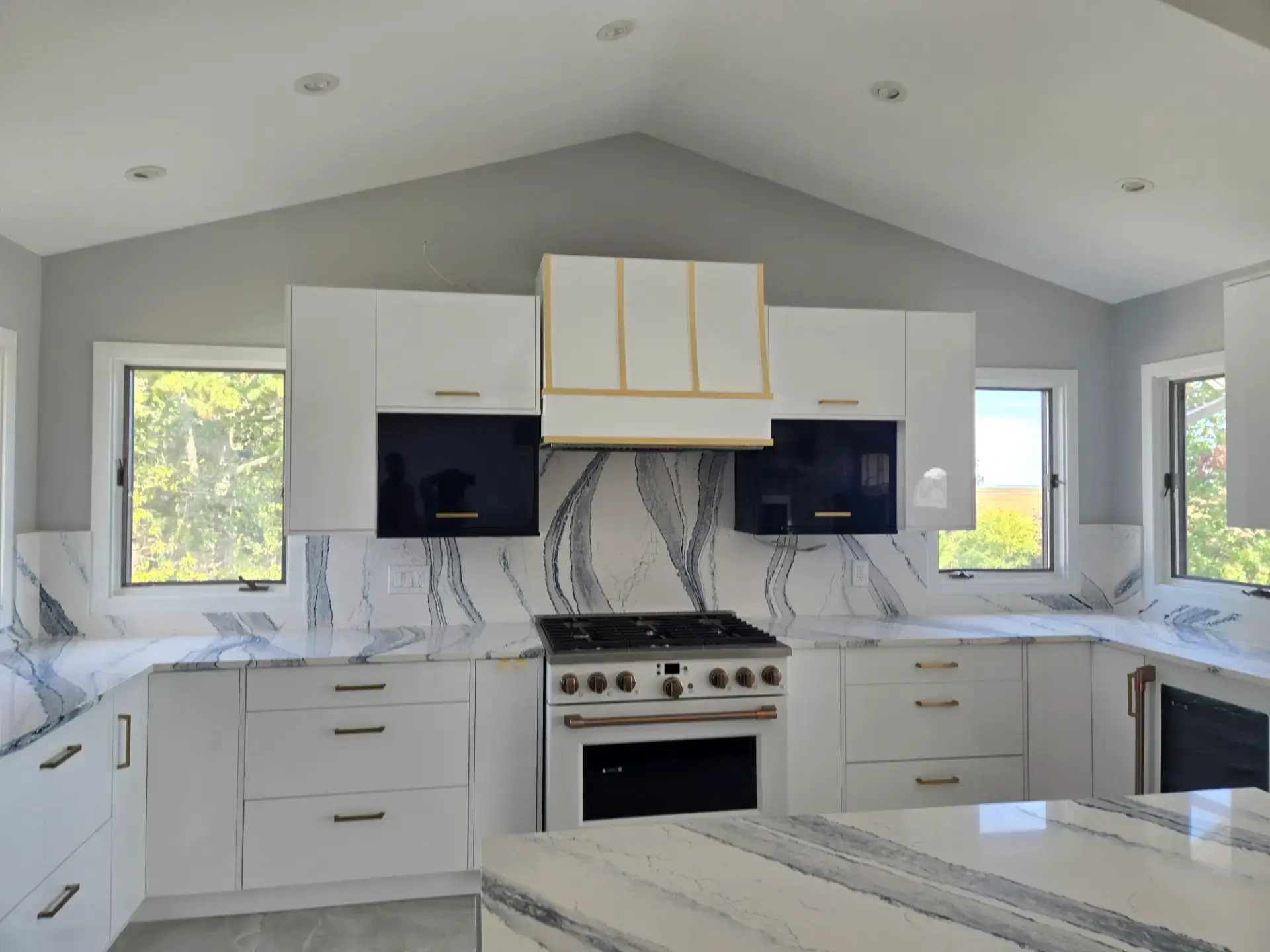 White and navy kitchen under a vaulted ceiling