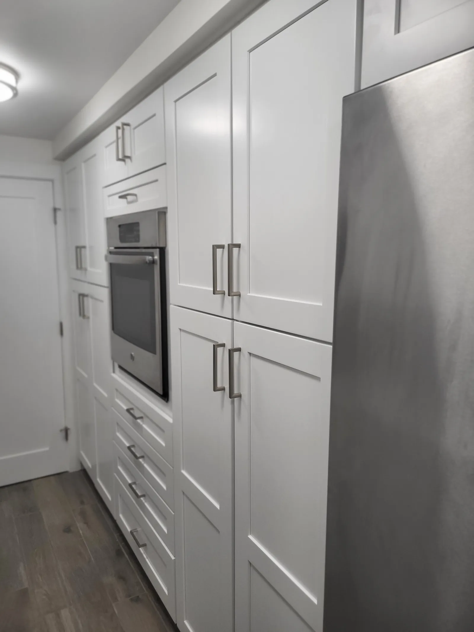 White shaker cabinetry with a full height appliance wall