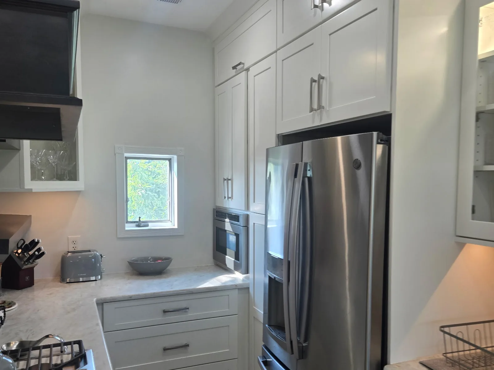 Tall cabinetry with a built in wall oven and fridge surround, another angle