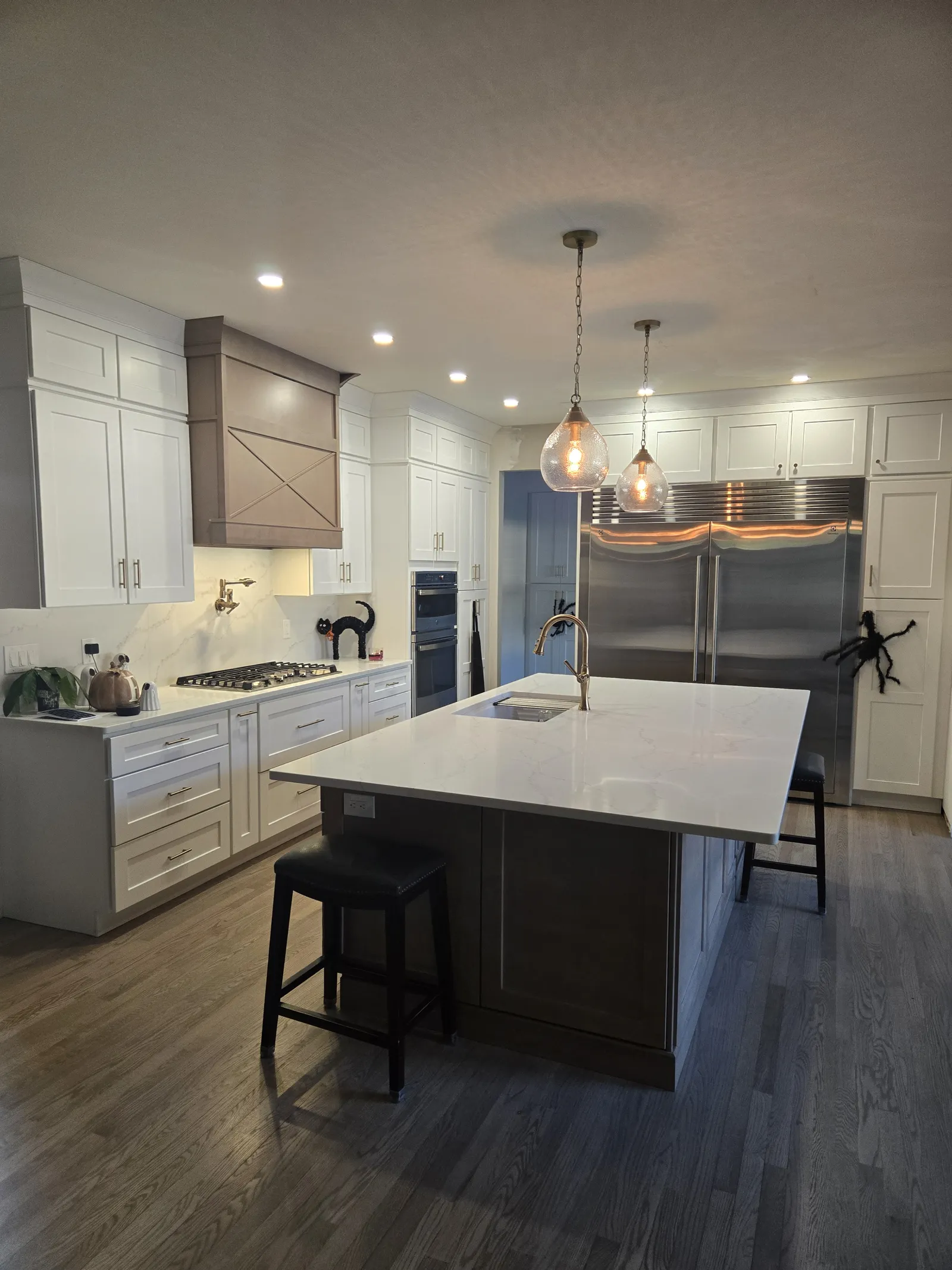 White kitchen with a stained wood island and pendants