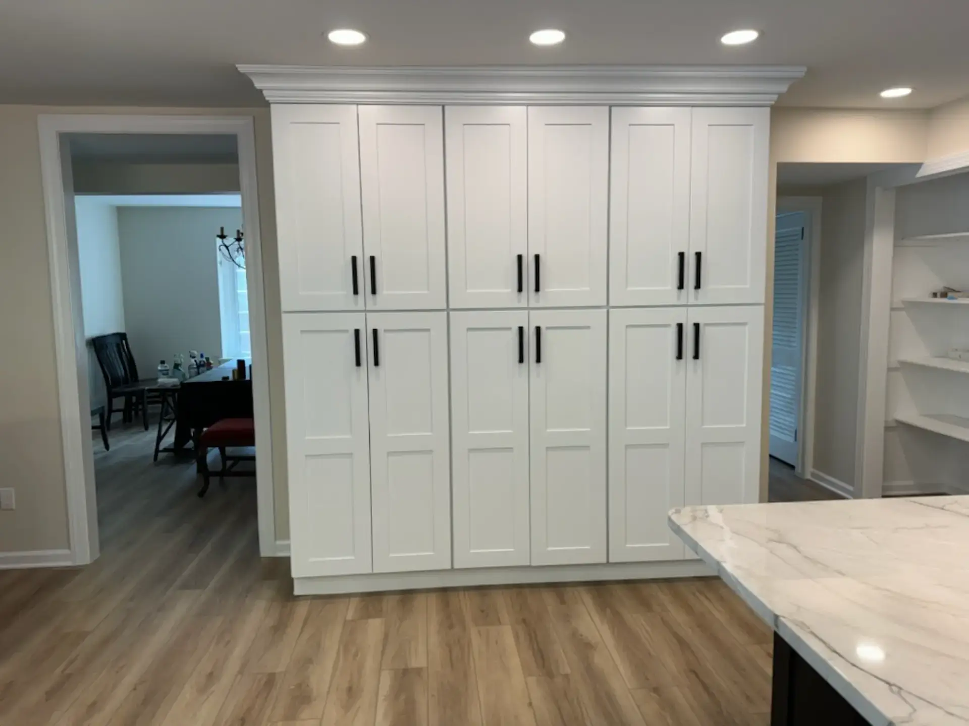 Tall white pantry cabinetry with full length doors